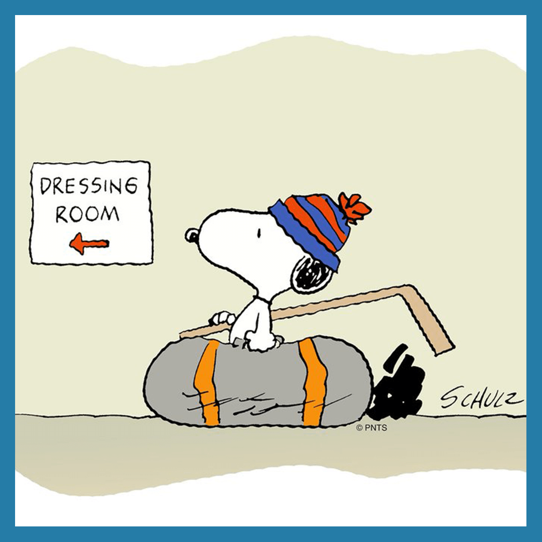 Snoopy wearing a toque and carrying a hockey stick and hockey bag.